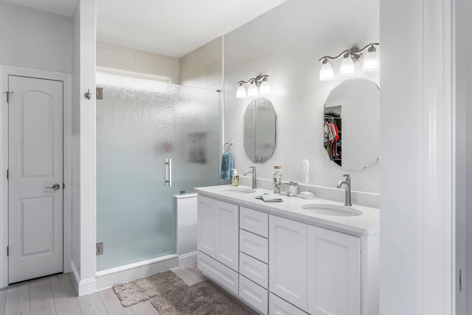 bathroom big with glass shower door and tewo mirrior