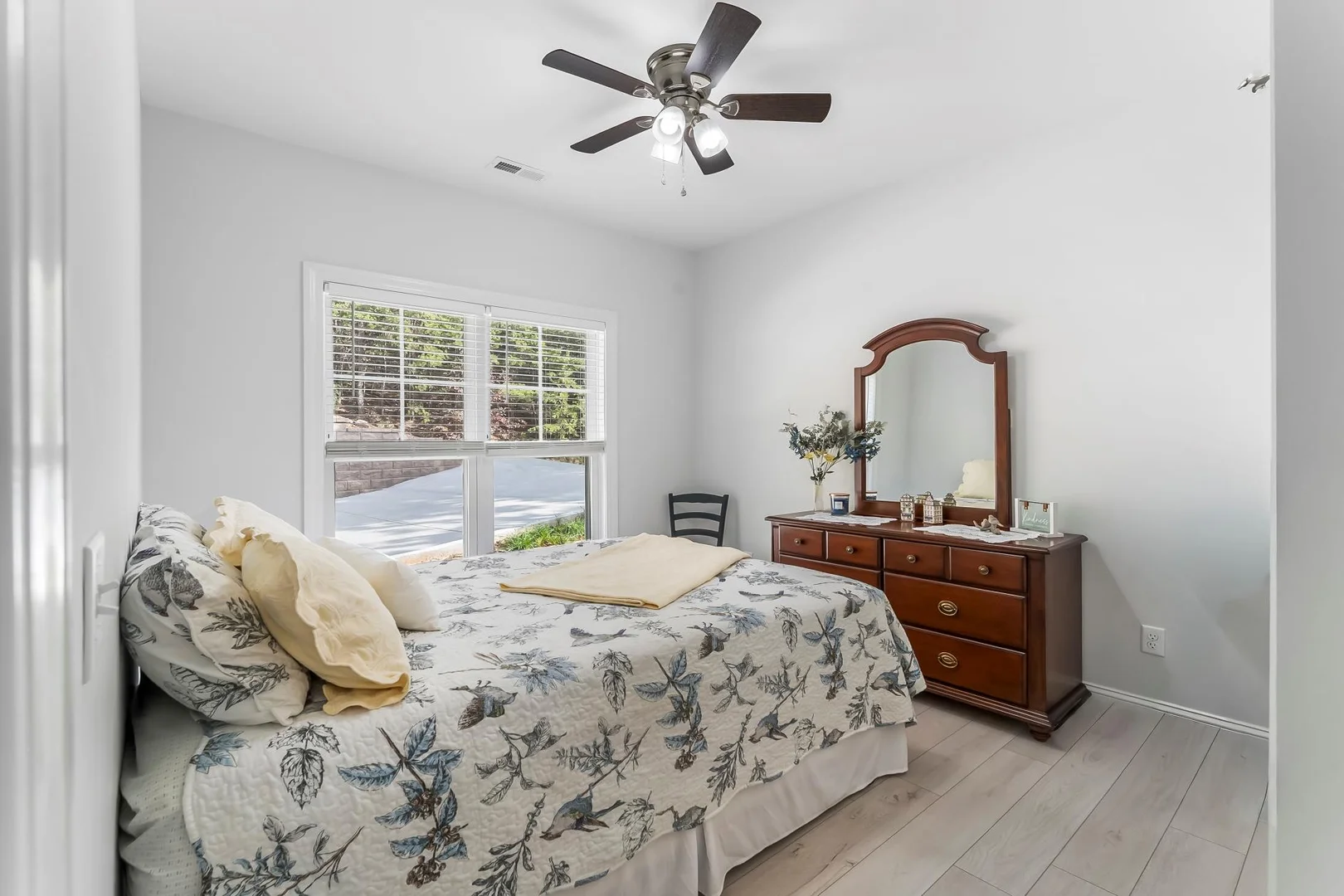 bedroom bigger brown dresser in front and windows to far left