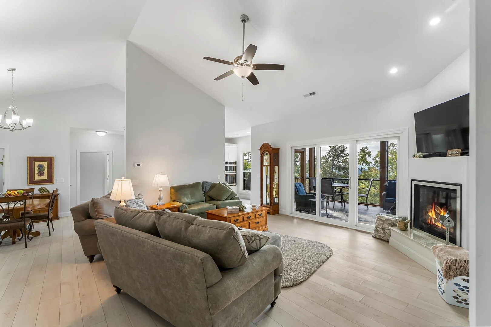living room side view with window doors on right and fire on right with dining room far left